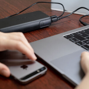 Black RAVPower RP-PB201 power bank charging a laptop and phone